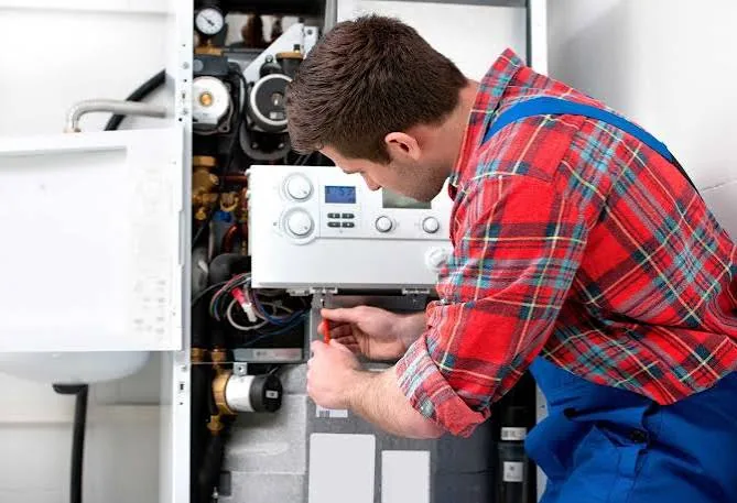 Technician servicing the controls inside a furnace