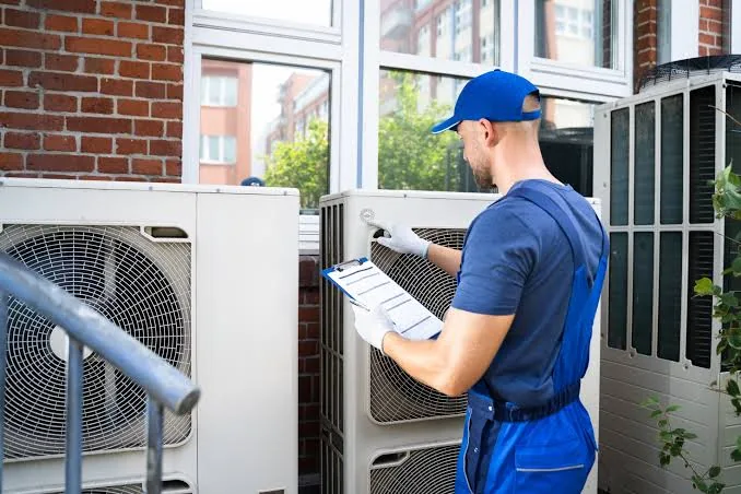 Technician inspecting outdoor heat pump equipment